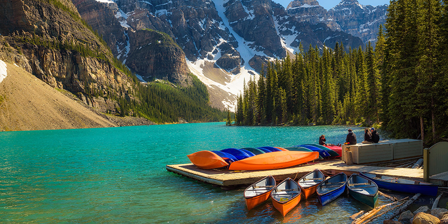 Canoes On A Jetty At Moraine Lake In Banff National Park