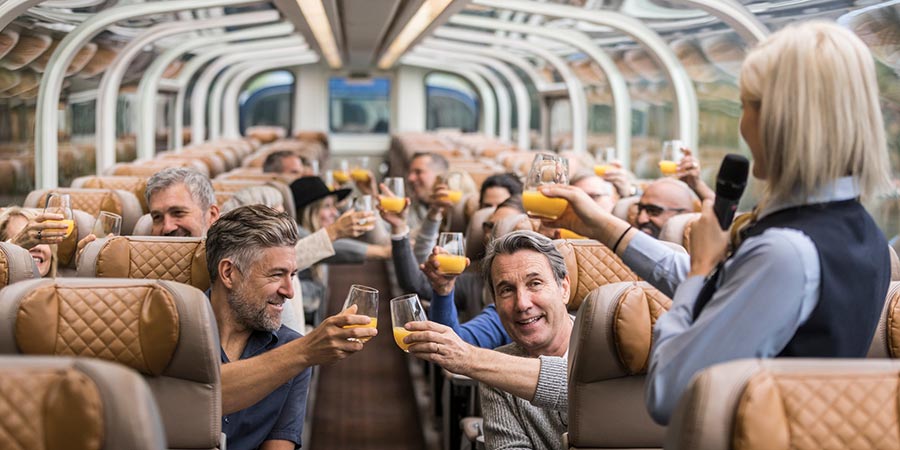 The host and customers raise their drink glasses in the panoramic carriage.
