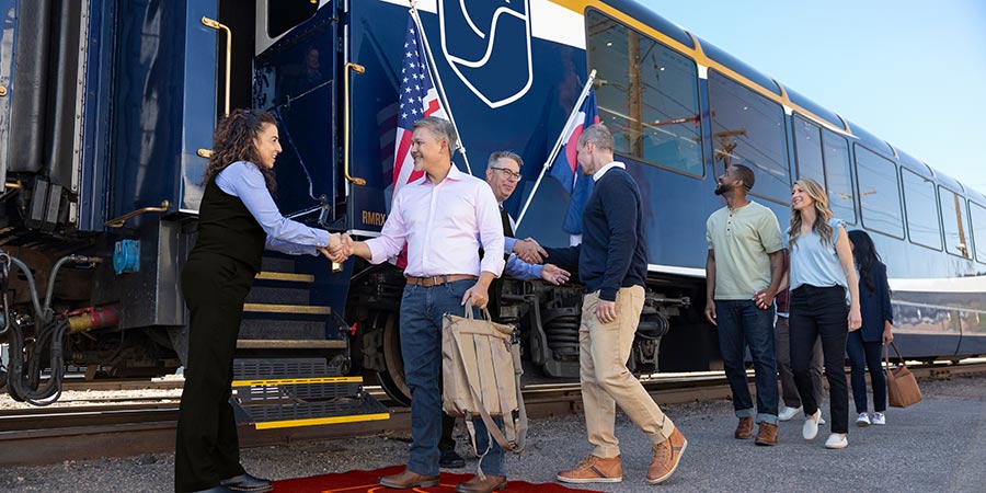 Customers boarding the Canyon Spirit train carriage with their luggage.